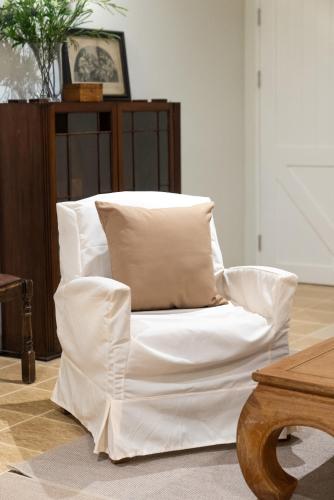 a white chair with pillows in a living room at Green Me Organic Farm Khao Yai กรีนมี ออแกนิคฟาร์ม เขาใหญ่ in Ban Khlong Yang