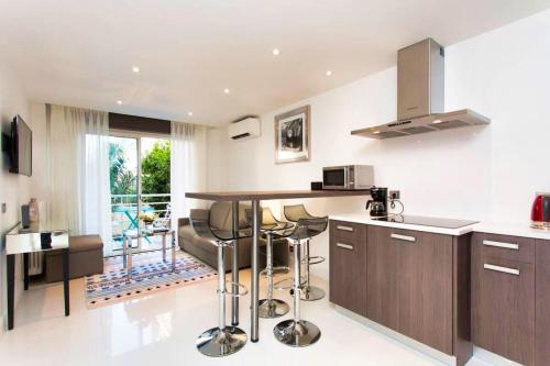 une cuisine avec un comptoir et un bar avec tabourets dans l'établissement Ref DRA by Palmes dProperties, à Cannes
