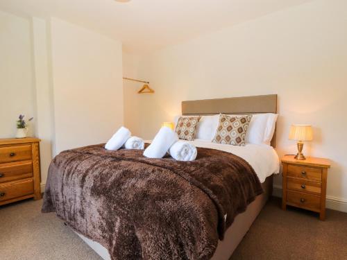 une chambre avec un grand lit avec deux tables de nuit dans l'établissement Holborn Cottage, Blencathra Street, à Keswick