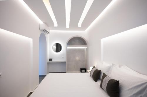 a white bedroom with a bed and a ceiling at Soil of Sun Luxury Villas in Megalokhori
