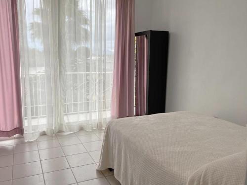 a bedroom with a bed and a window with pink curtains at Departamento 3Hab 7min del Centro in Tehuacán