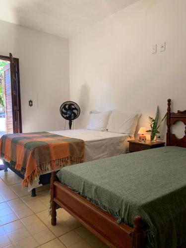 een slaapkamer met twee bedden in een kamer bij Suíte Pitangueira - Hospedaria Sonho De Infância in Mato Verde