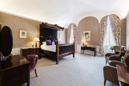 a large room with a bed and chairs in it at Winchester Royal Hotel in Winchester