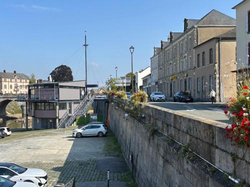 a city street with cars parked next to a wall at chambre d hotes chez josiane in Mayenne