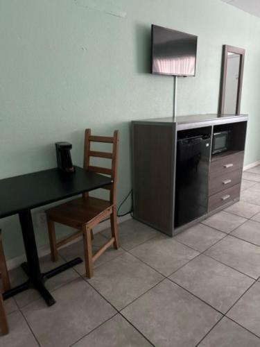 a room with a table and a chair and a television at Royal Canadian Motel in Wildwood