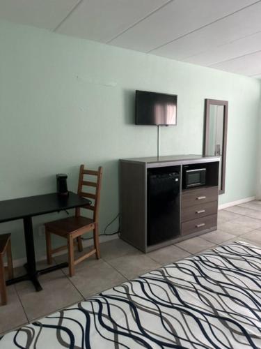 a room with a desk and a television and a chair at Royal Canadian Motel in Wildwood