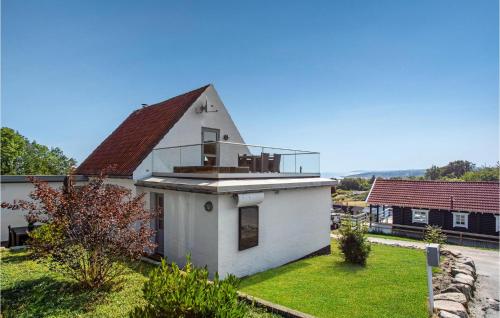 a small white house with a balcony on the roof at 3 Bedroom Gorgeous Home In Allinge in Allinge