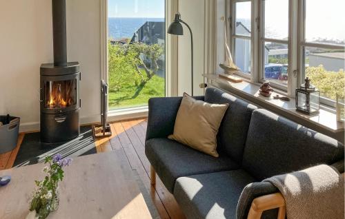 a living room with a couch and a fireplace at 3 Bedroom Gorgeous Home In Allinge in Allinge