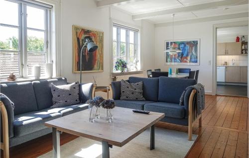 a living room with blue couches and a table at 3 Bedroom Gorgeous Home In Allinge in Allinge
