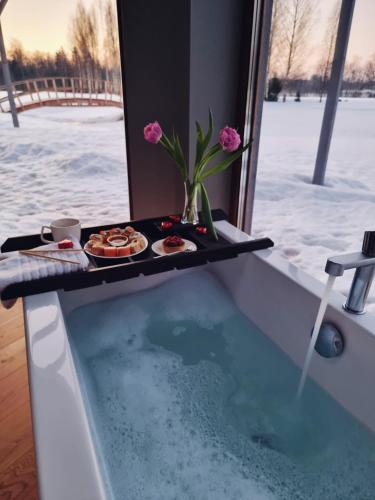 a bath tub with a tray of food in it at Dabas Osta in Jūdaži