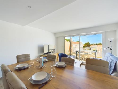 une salle à manger avec une table et des chaises en bois dans l'établissement Appart pour 4 centre ville - proche de la gare, à Saint-Hilaire-de-Riez