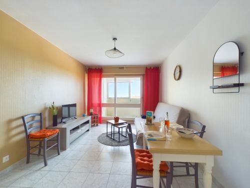 une cuisine et un salon avec une table et des chaises dans l'établissement Appart pour 4 - Loggia vue mer - 250m de la plage, à Plage-des-Demoiselles
