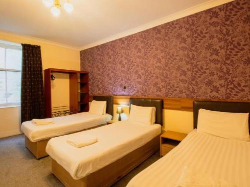 a hotel room with two beds and a window at The Ben Mhor Hotel, Bar & Restaurant in Grantown on Spey