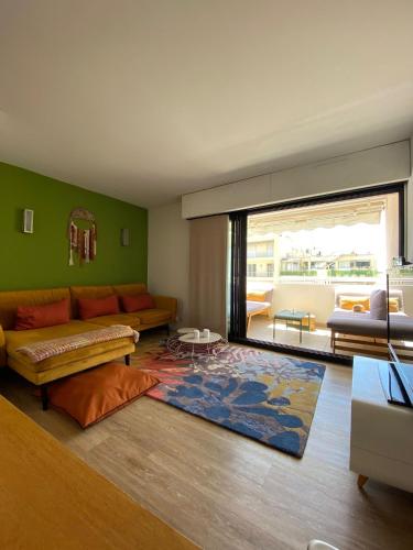 un salon avec un canapé et un tapis dans l'établissement T3 pièces lumineux à à 1 min de la plage Quartier Palm Beach Cannes, à Cannes