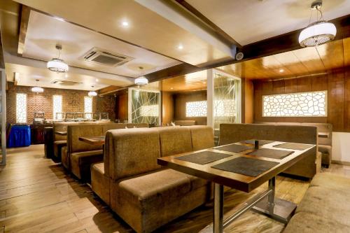 a restaurant with chairs and a table and a bar at Palette River Front Railway Station Formerly Host Inn in Ahmedabad
