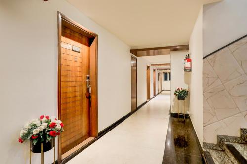 a corridor of a hotel with a door and flowers at Palette River Front Railway Station Formerly Host Inn in Ahmedabad