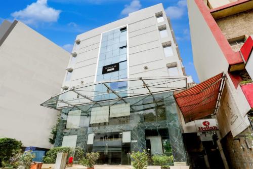 a tall white building with a glass facade at Palette River Front Railway Station Formerly Host Inn in Ahmedabad