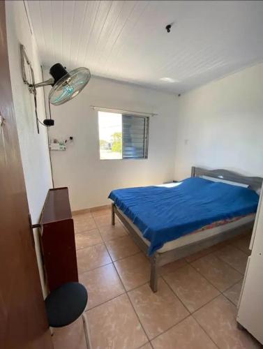 a bedroom with a bed with a blue sheets and a window at Apartamentos L & L in Rio Grande