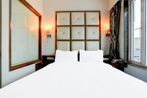 a bedroom with a large bed and two windows at Palette River Front Railway Station Formerly Host Inn in Ahmedabad