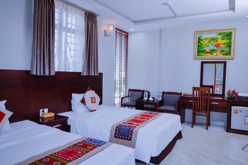 a hotel room with two beds and a desk at Khách sạn 88 mộc châu in Mộc Châu