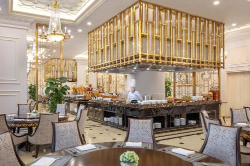 a restaurant with tables and a man in the background at Melia Vinpearl Quang Binh in Dong Hoi