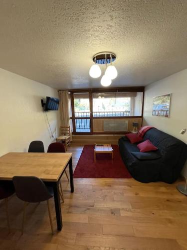 un salon avec un canapé et une table dans l'établissement Appart Cosy au centre du village, à Saint-Lary-Soulan