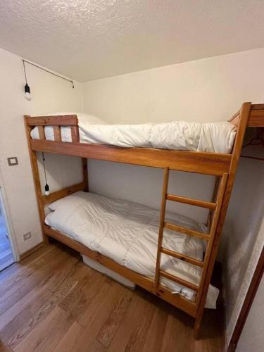 Ce dortoir comprend 2 lits superposés et des draps blancs. dans l'établissement Appart Cosy au centre du village, à Saint-Lary-Soulan