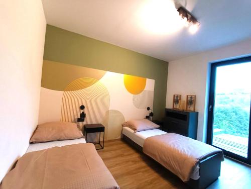 a bedroom with two beds and a window at Rosochata313 Domek w górach z Sauną Jacuzzi i Basenem Panieński ruska Bania in Mogilno