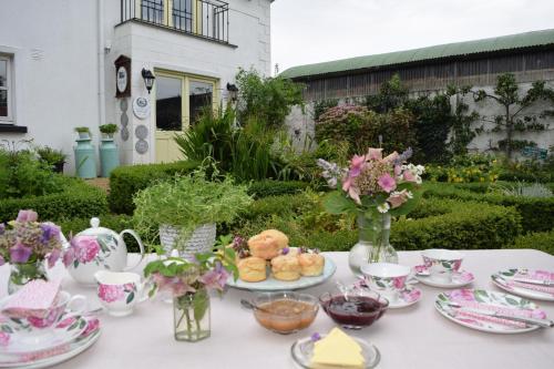 a table with plates of food and flowers on it at Ballyknocken Milking Parlour Self Catering Apartment in Coolnakilly