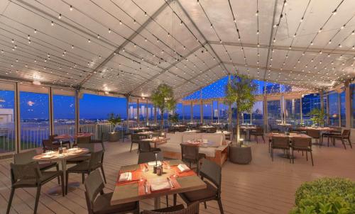 a rendering of a restaurant with tables and chairs at The Beverly Hilton in Los Angeles