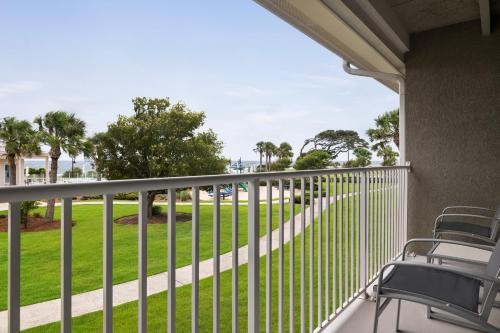 a balcony with chairs and a view of a park at Holiday Inn Resort Jekyll Island by IHG in Jekyll Island