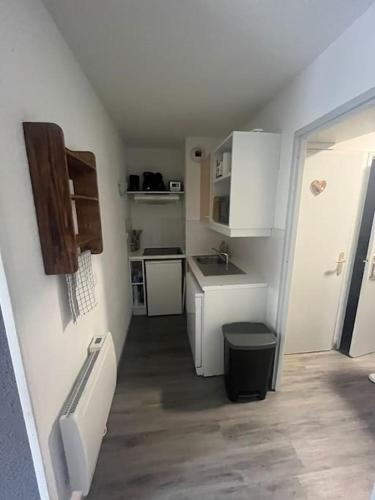 une petite cuisine avec des armoires blanches et un évier dans l'établissement Appartement au pied des pistes, à Saint-François-Longchamp