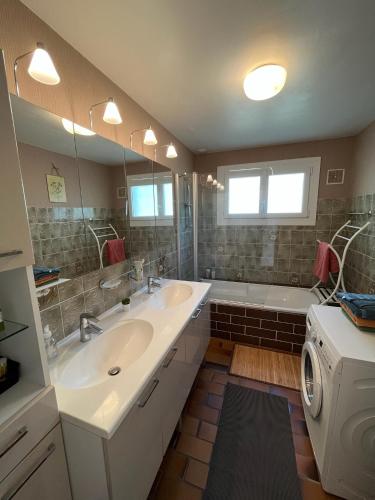 une salle de bain avec deux lavabos et une machine à laver dans l'établissement Maison familiale Hakuna Matata au cœur de la Palmyre, aux Mathes