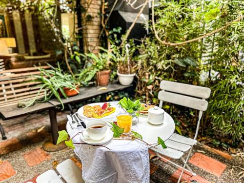 a table with a plate of food and drinks on it at Lucitania Hotel Boutique in Bogotá