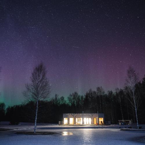 a house under a starry night with the milky way at Dabas Osta in Jūdaži