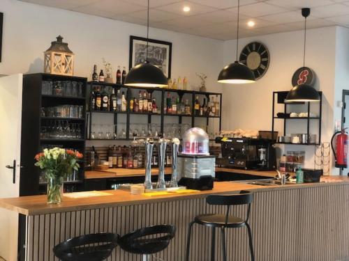 un bar avec deux tabourets à un comptoir dans une pièce dans l'établissement Love SPA, à Oye-Plage