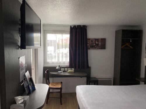 a hotel room with a bed and a desk and a window at Brit Hotel Reims La Neuvillette in Reims