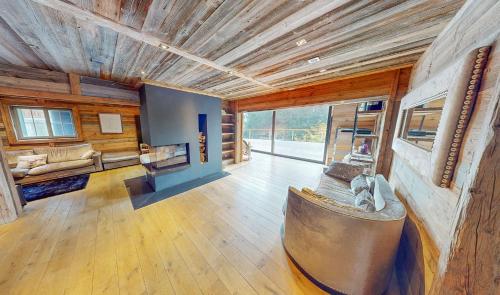 sala de estar amplia con sofá grande y chimenea en Les Pives, en Icogne
