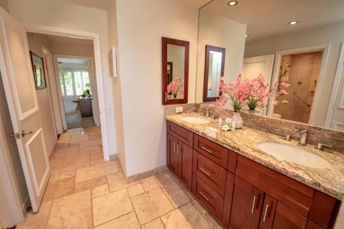 een badkamer met twee wastafels en een grote spiegel bij Elua 704 in Wailea