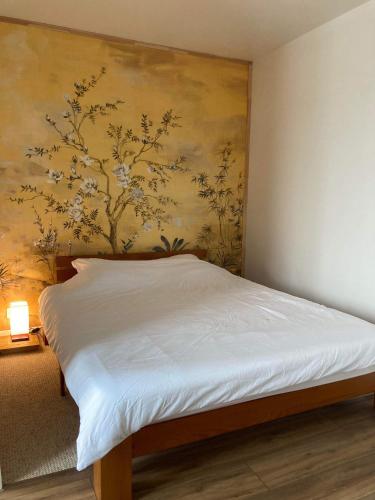 un lit dans une chambre avec un tableau sur le mur dans l'établissement La Japan House, au Mans