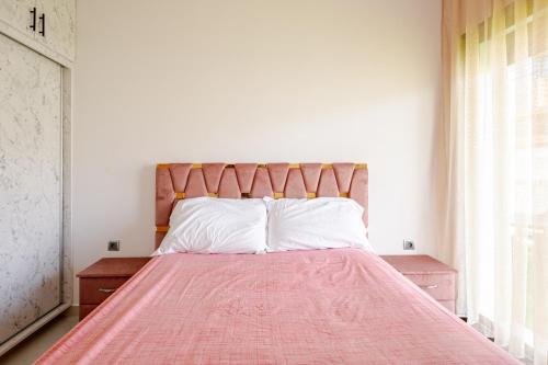 a bedroom with a bed with a pink blanket on it at Appartamento con piscina privata in Pont Blondin