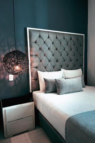 a bedroom with a large bed with a large headboard at Dharma Hotel Boutique Spa in San Jerónimo