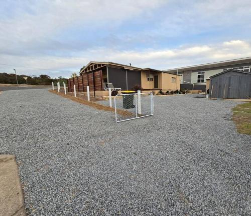 a parking lot with a fence in front of a building at Howsthaserenitee - 3BR house with bay views in Coffin Bay