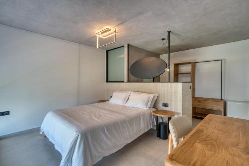 a bedroom with a bed and a wooden table at Anima Deluxe Suites in Nafplio