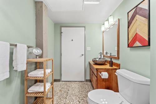 a bathroom with a sink and a toilet and a mirror at 310-Cozy DT Haven Cafe Wi-Fi Parking in Cleveland