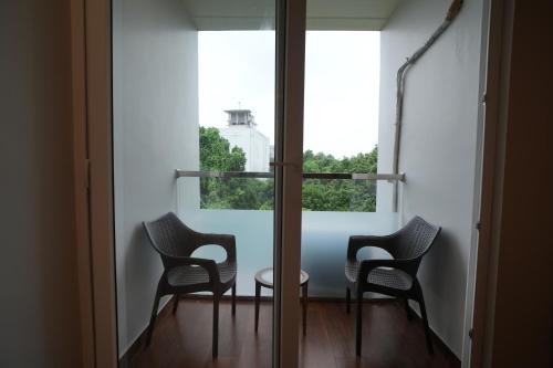 two chairs and a table in a room with a window at Alokah Kashi in Varanasi