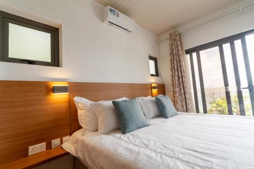 a bedroom with a large bed with a window at Sorento Holiday Apartments in Glacis