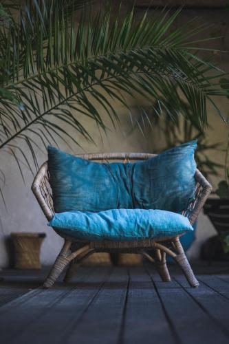 a wicker chair with blue pillows in a living room at Hôtel Ville d'Hiver in Arcachon