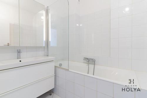 une salle de bain blanche avec un lavabo et un miroir dans l'établissement Proche Porte Maillot - Le Véritable - 378B, à Paris