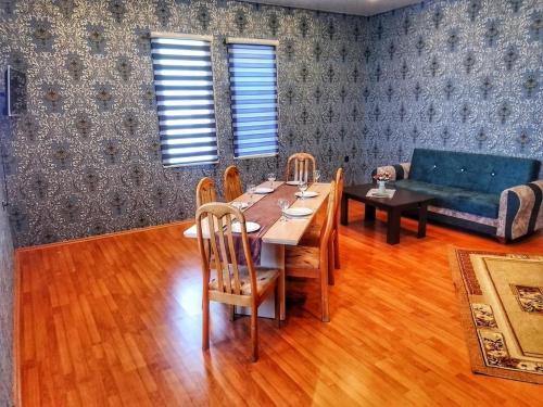 a dining room with a table and a blue couch at Garden F Sheki in Sheki